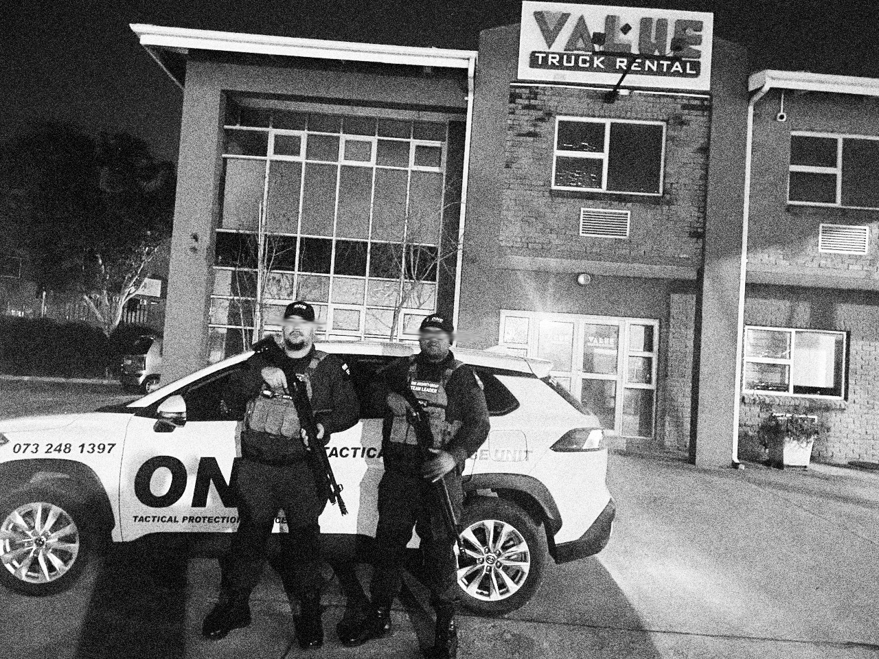 Armed ONE tactical officer and Team Leader on site at night beside a ONE response vehicle