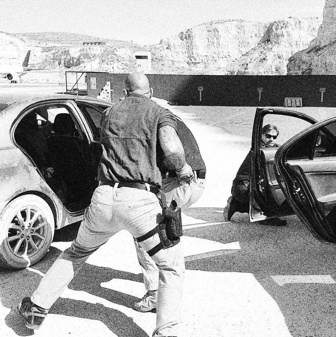 Close protection officers training vehicle drills on a range